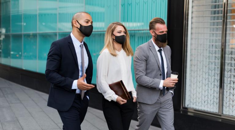 business people walking streets with masks on