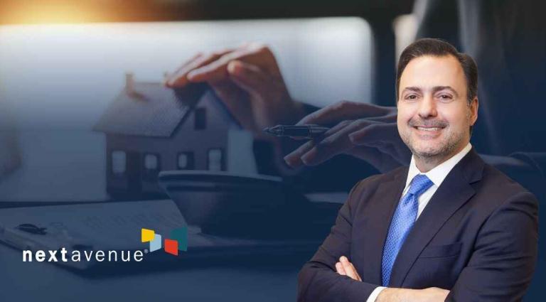 Asher Rubinstein in the right foreground of an image of hands holding a pen next to a calculator and miniature house model and the GDB logo in the bottom left corner